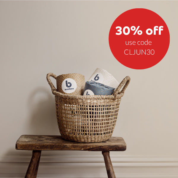 Woven basket with wrapped bamboo toilet rolls on a wooden stool against a beige wall, with a 30% off promotion label.