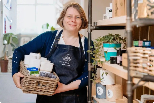 Person holding a basket of products in a store setting