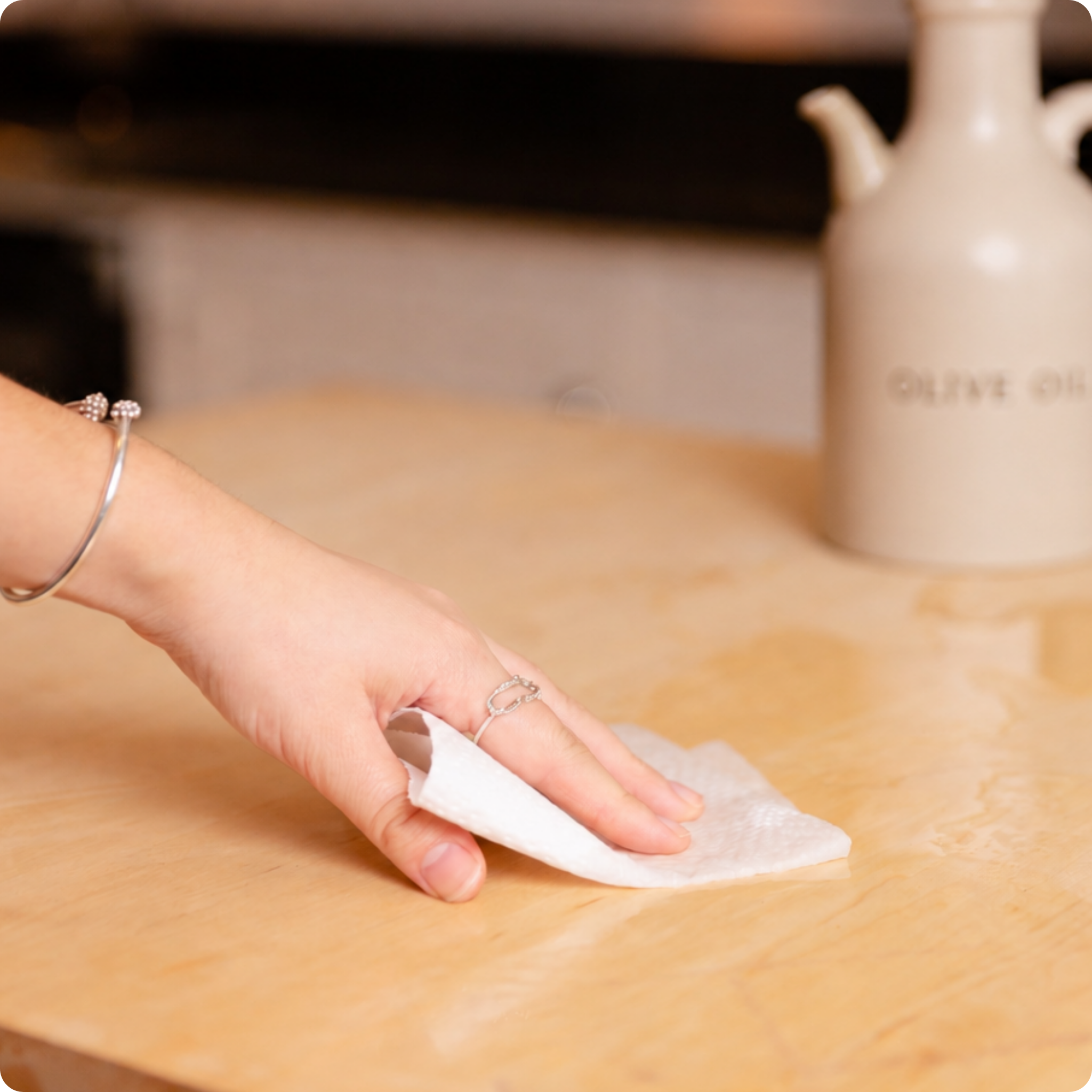 Hand wiping up spillage with bamboo kitchen rolls