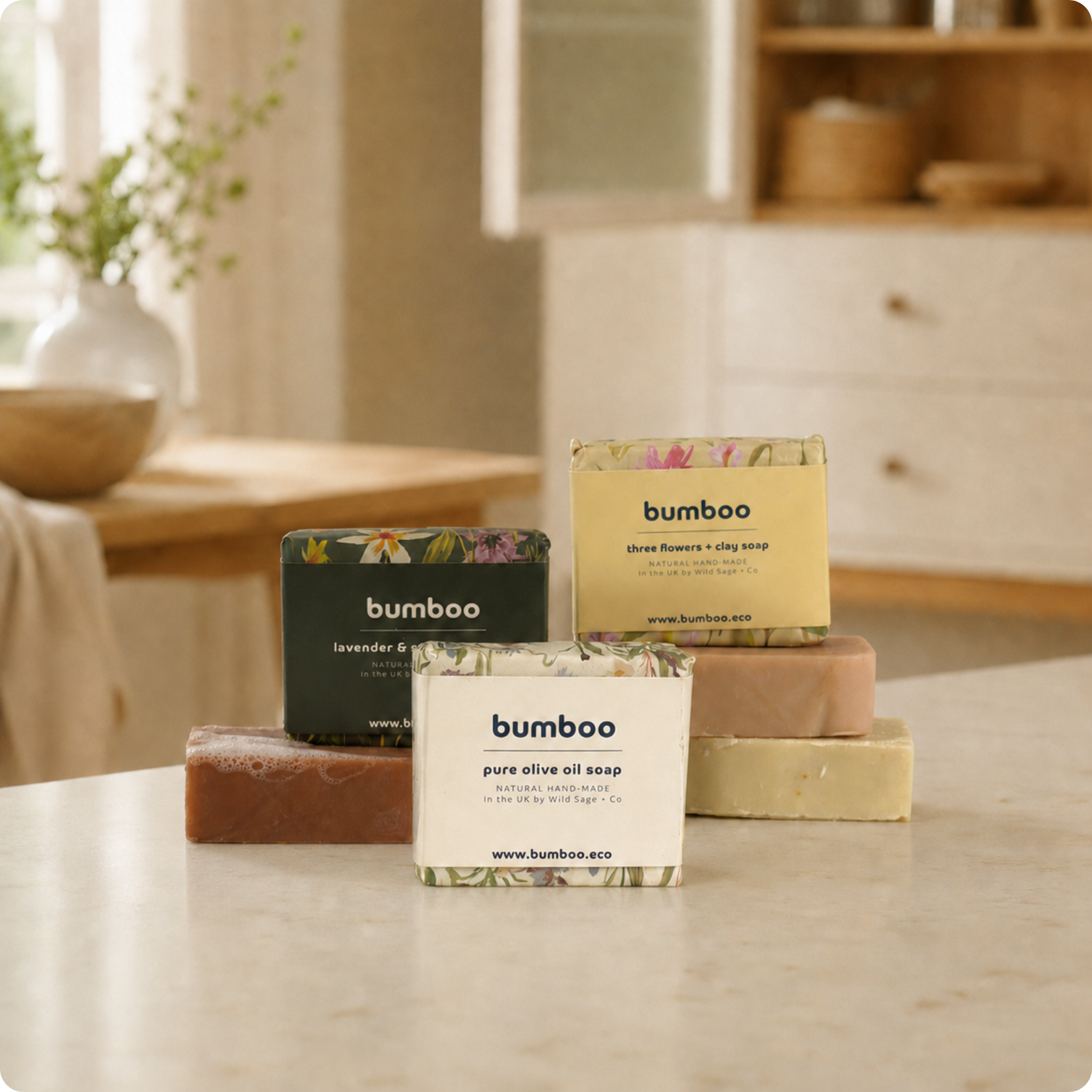 Stack of three handmade soap wrapped in floral paper in kitchen.