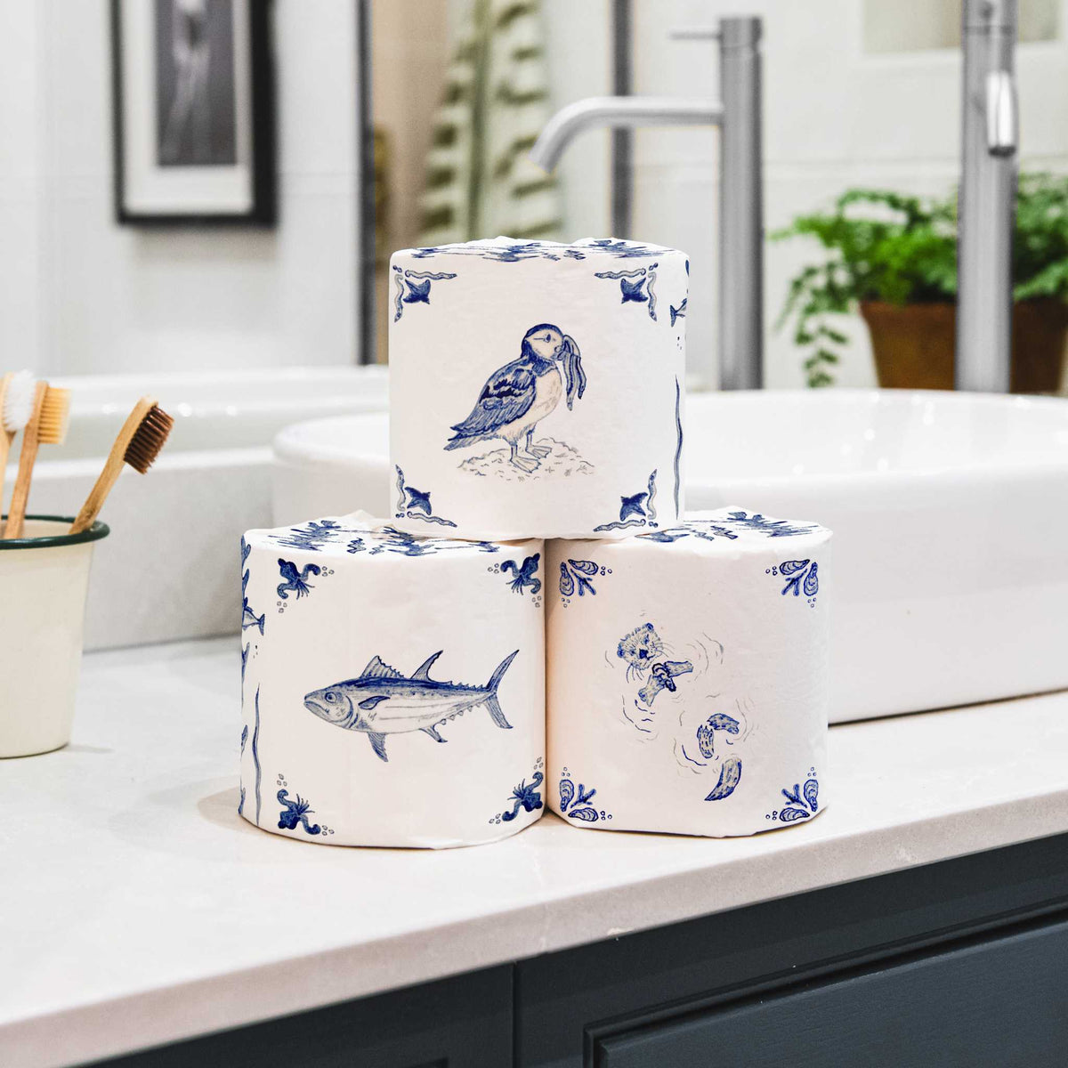 Stack of bamboo toilet paper wrapped in an english delft design in bathroom