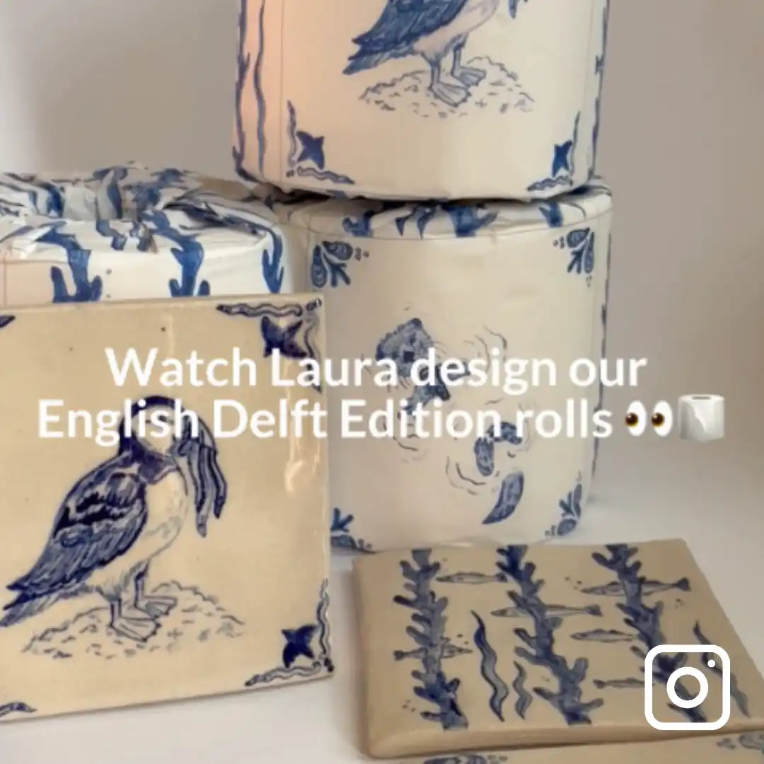 Stack of wrapped bamboo toilet rolls with blue and white patterns on a neutral background