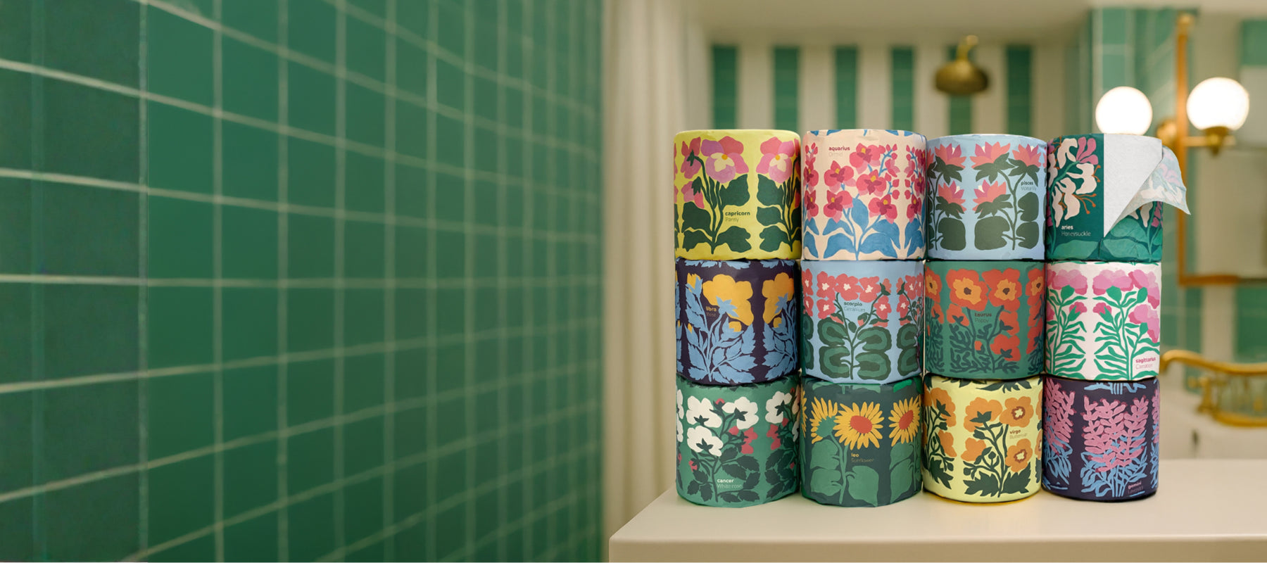 Wrapped colourful toilet rolls stacked on bathroom sink